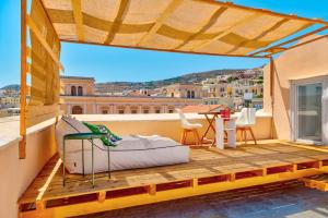 a balcony with a bed and a view of a city at Homey in Ermoupoli