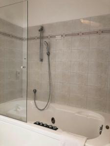 eine Badewanne mit einer Dusche und einer Glastür in der Unterkunft B&B "al Pesce Vela" in Albese Con Cassano