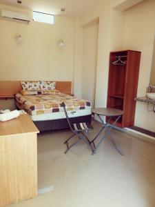 ein Schlafzimmer mit einem Bett, einem Tisch und einem Stuhl in der Unterkunft MAU Suite&Apartment in Máncora