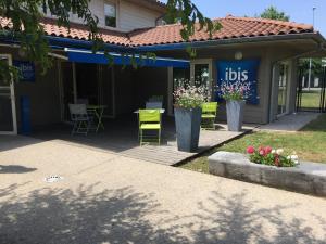 a green bench in front of a restaurant at ibis budget Bourg en Bresse in Bourg-en-Bresse