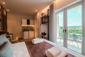a bedroom with a bed and a balcony with a kitchen at Frunze Luxury Apartments in Nafplio