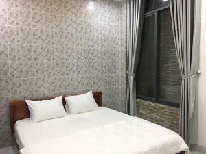 a bed with two pillows in a bedroom at Huynh Gia in Da Nang