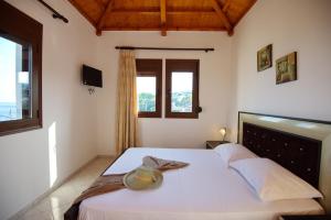 a bedroom with a bed with a hat on it at Esperides Maisonettes in Votsi