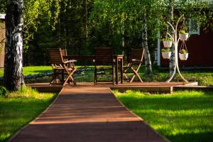 Una pasarela de madera con sillas y una mesa de picnic en un parque en Motelli Rovaniemi, en Rovaniemi