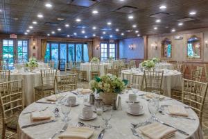 a banquet room with tables and chairs with white tablecloths at The Olde Mill Inn Basking Ridge in Basking Ridge