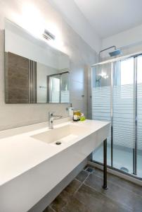 a bathroom with a sink and a mirror at Aegean Horizon Beachfront Villas in Gennadi