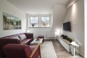 Una sala de estar con un sofá y un televisor. en dat geele hus 1, en Büsum