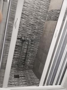 y baño con ducha de azulejos. en Meltemi Beach Apartments en Milatos