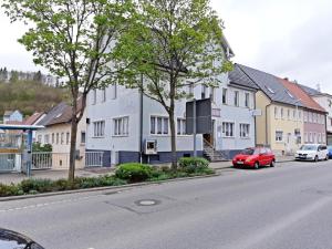 un'auto rossa parcheggiata di fronte a una fila di case di Hotel & Hostel Albstadt ad Albstadt