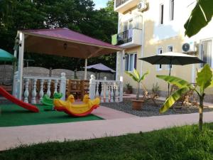 a playground with a slide and an umbrella at Shekvetili+ in Shekvetili