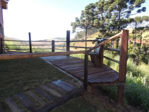 a wooden walkway with a fence and a tree at Refúgio Horse in Santo Antônio do Pinhal
