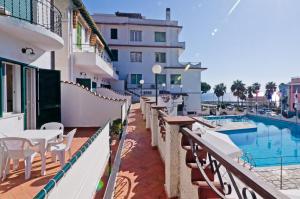 a balcony with tables and chairs and a swimming pool at Hotel Ariston Montecarlo in Sanremo