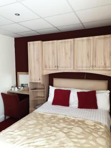 Schlafzimmer mit einem Bett mit roten und weißen Kissen in der Unterkunft The Montclair in Blackpool