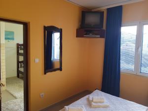 a bedroom with a mirror and a tv on the wall at Apartments Sandra in Tivat