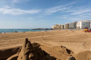 una escultura de arena en una playa con edificios en el fondo en Yellow Sun Marine I By CanariasGetaway, en Las Palmas de Gran Canaria