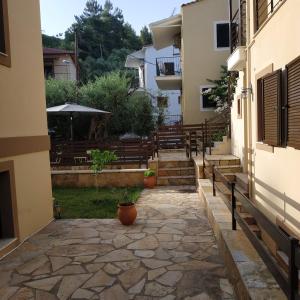 a courtyard of a house with a stone walkway at AnGeo Maisonettes in Sivota