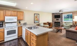 a kitchen with a sink and a living room at Club Wyndham Tamarack in Wisconsin Dells