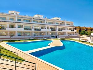 a large building with a large pool in front of it at Vilamoura - Cozy and Quiet Holiday Apartment in Vilamoura