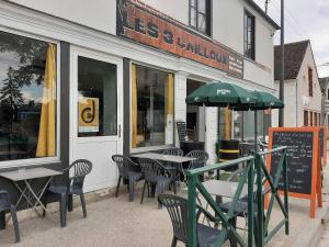 un restaurant avec des tables, des chaises et un parasol dans l'établissement Les 3 Cailloux Bar Restaurant, à Gurgy