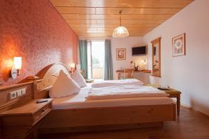 a bedroom with a bed and a desk and a window at Gasthof Zur Burg in Ewattingen