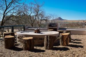 a teddy bear sitting on a table with logs around it at Merino Guest Farm in Clarens