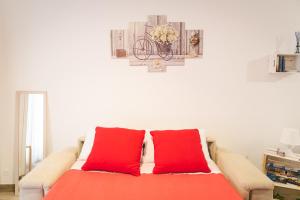 - un canapé avec deux oreillers rouges dans le salon dans l'établissement Souvenir d'été, à Mola di Bari