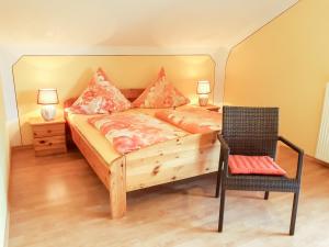 ein Schlafzimmer mit einem Holzbett und einem Stuhl in der Unterkunft FeWo Kreitl in Waldmünchen