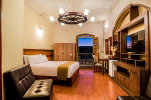 Habitación de hotel con cama y TV en Majestad Hotel Boutique, en Arequipa