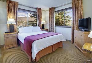 a hotel room with a bed and a television at Heidelberg Inn & Resort in June Lake