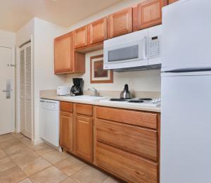 a kitchen with wooden cabinets and a white refrigerator at WorldMark Grand Lake in Monkey Island +15 photos