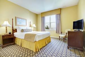 a hotel room with a bed and a flat screen tv at Club Wyndham Bay Voyage Inn in Jamestown