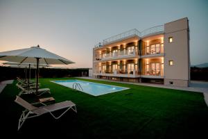 a house with a swimming pool and an umbrella and chairs at Frunze Luxury Apartments in Nafplio