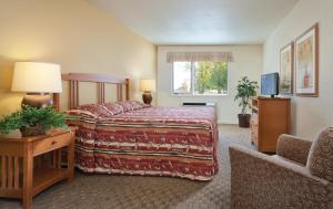 a hotel room with a bed and a chair at WorldMark Grand Lake in Monkey Island
