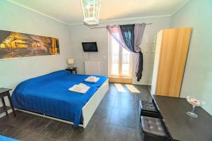 a bedroom with a blue bed and a window at Rooms Gli arcangeli 2 - Affitti Brevi Italia in Monte SantʼAngelo