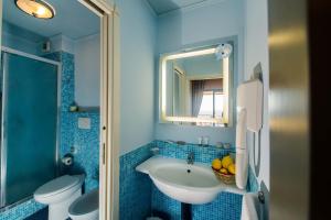 
a bathroom with a sink, toilet, and bathtub at Capo Dei Greci Taormina Coast Hotel & SPA in Santa Margherita-Sant'Alessio Siculo
