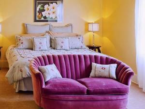 a large bed with a purple couch in a room at Hydrangea Inn in Eureka
