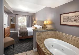 ein Hotelzimmer mit einem Bett und einer Badewanne in der Unterkunft Vino Bello Resort in Napa