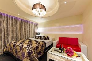 sypialnia z łóżkiem, kanapą i żyrandolem w obiekcie HOTEL VERSYS (Adult Only) w mieście Hiroszima