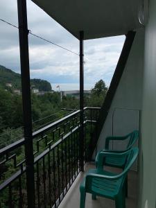 2 Stühle auf einem Balkon mit Aussicht in der Unterkunft Temo's Guesthouse in Sarpi