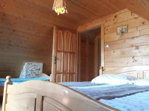 a bedroom with a bed in a log cabin at Domek letniskowy Michałówka in Łeba