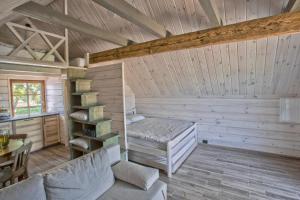 Zimmer mit einem Bett und einem Regal in einer Hütte in der Unterkunft Family house Vila Rica in Ricieliai