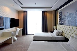 a hotel room with two beds and a television at Jindagu Hotel Ipoh in Ipoh