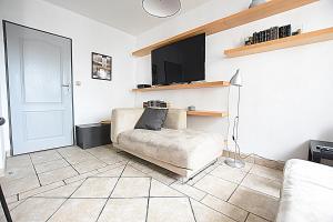 ein Wohnzimmer mit einem Sofa und einem Flachbild-TV in der Unterkunft Mhost Bronowice in Krakau
