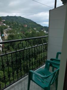 two green chairs sitting on a balcony with a view at Temo's Guesthouse in Sarpi