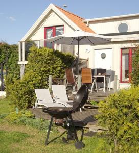 eine Terrasse mit Stühlen, einem Sonnenschirm und einem Tisch in der Unterkunft 1A, Stuga med 50m till strand in Byxelkrok