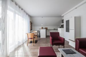 Una sala de estar con sillas rojas y una cocina. en dat geele hus 5, en Büsum