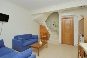a living room with a blue couch and a staircase at Manoleas Villas - Apartment 8 in Stoupa