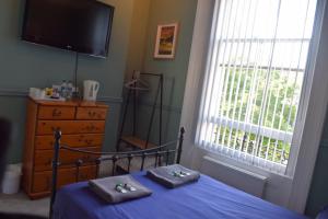 a bedroom with a bed with two towels on it at Westward Ho Hotel in Folkestone