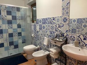 a blue and white bathroom with a toilet and a sink at TENUTA BOSCO-Casa Vacanze in Cetara