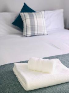 a white towel sitting on top of a bed at Balderton Lodge in Balderton